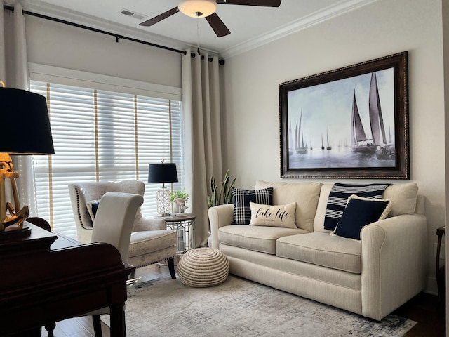 living room featuring visible vents, a ceiling fan, and ornamental molding