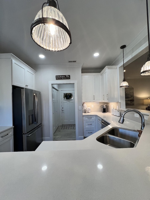 kitchen featuring visible vents, white cabinets, stainless steel fridge with ice dispenser, crown molding, and a sink