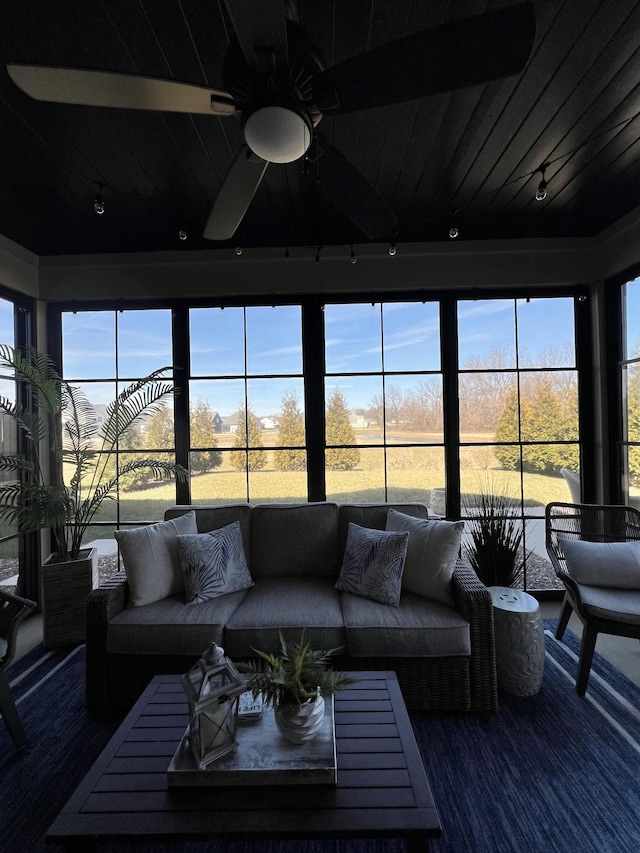 sunroom / solarium featuring track lighting, wooden ceiling, and a healthy amount of sunlight