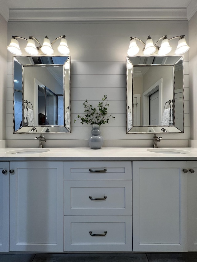 full bathroom featuring double vanity, crown molding, and a sink