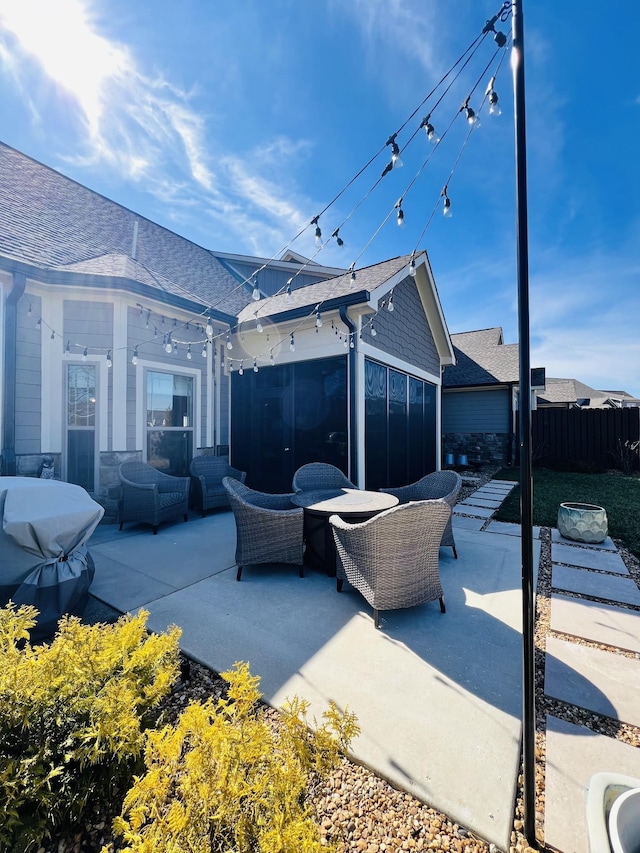 view of patio / terrace featuring a sunroom, fence, and an outdoor hangout area