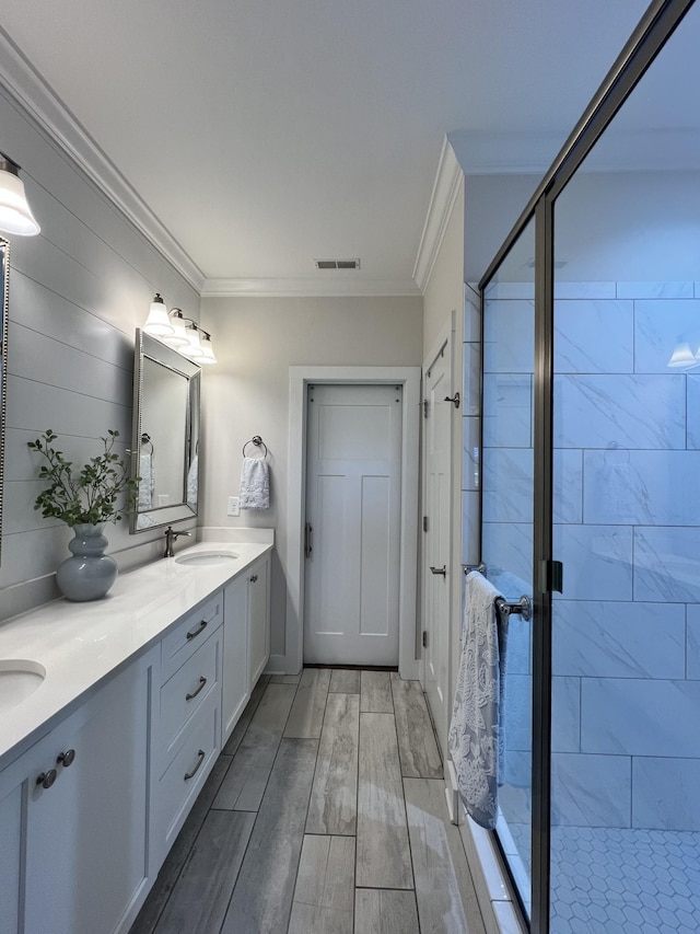 full bathroom with ornamental molding, a sink, visible vents, and a shower stall