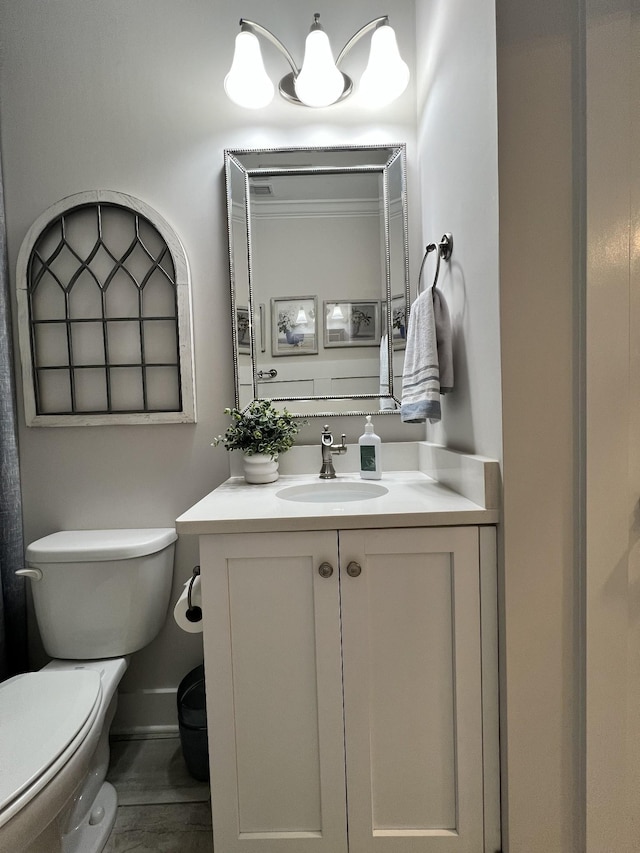 bathroom with toilet, baseboards, and vanity