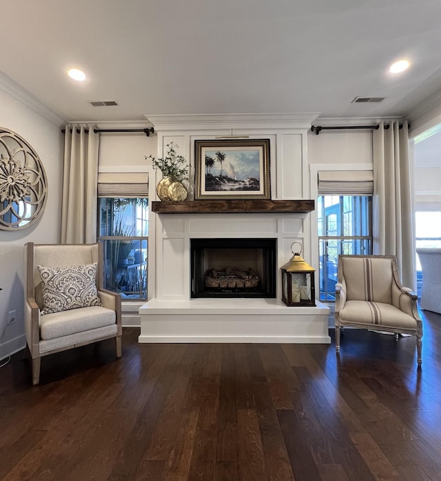 sitting room featuring a fireplace, wood finished floors, visible vents, and crown molding