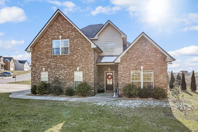 traditional-style home with a shingled roof, a front lawn, and brick siding