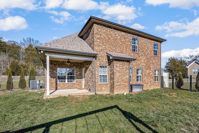 back of house featuring brick siding, a lawn, and a patio