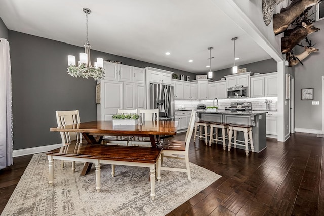 dining room with dark wood-style floors, recessed lighting, baseboards, and an inviting chandelier