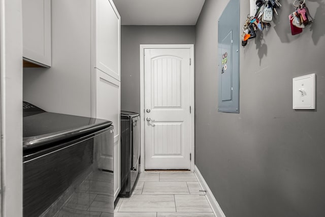 washroom with washer and dryer, electric panel, cabinet space, and baseboards