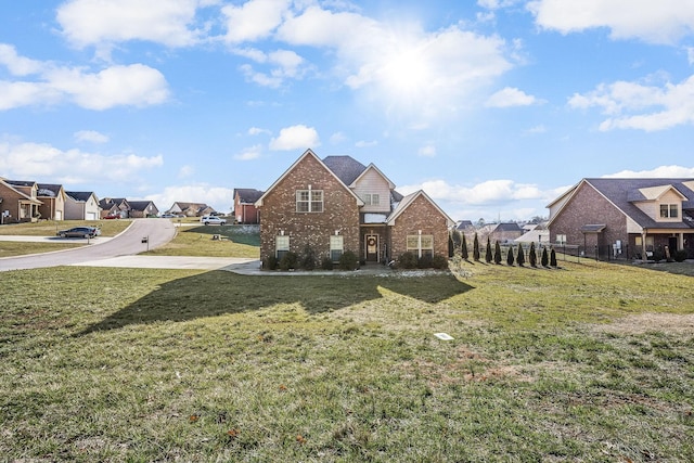 exterior space featuring brick siding, a residential view, and a front yard