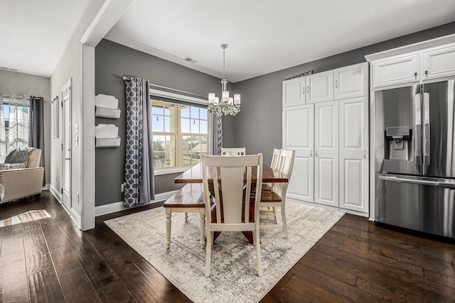 dining area with dark wood-type flooring, visible vents, baseboards, and an inviting chandelier