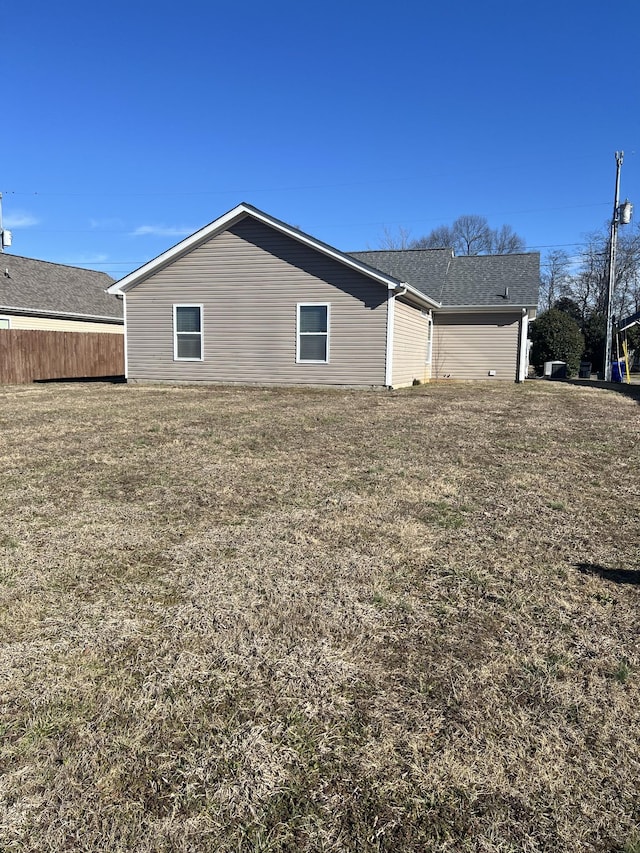 view of property exterior featuring fence and a lawn