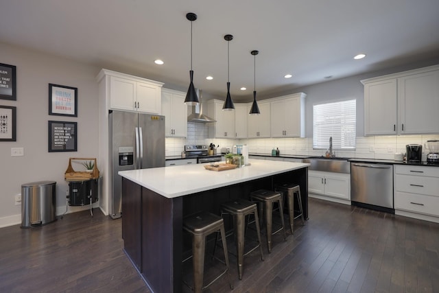 kitchen with hanging light fixtures, white cabinetry, appliances with stainless steel finishes, and a center island