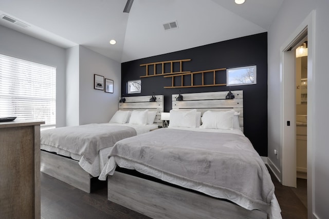 bedroom featuring lofted ceiling, dark wood-style floors, and visible vents