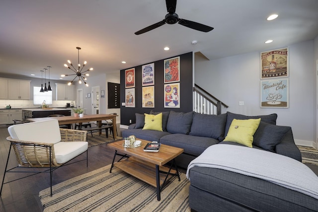 living area with ceiling fan with notable chandelier, stairway, wood finished floors, and recessed lighting