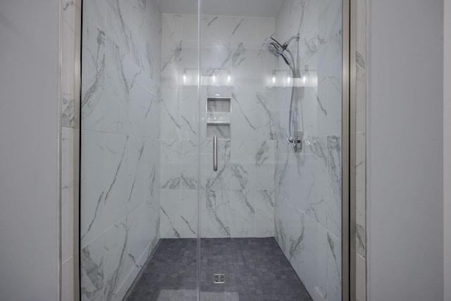 bathroom featuring a marble finish shower