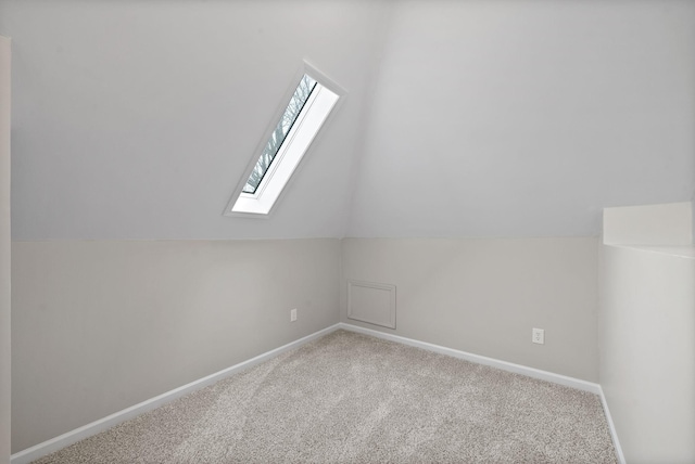 additional living space with lofted ceiling with skylight, carpet, and baseboards