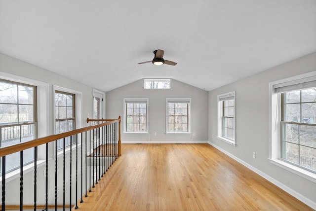 unfurnished room with lofted ceiling, light wood-style flooring, and a wealth of natural light