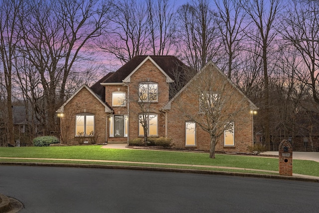 traditional-style home with a front lawn and brick siding