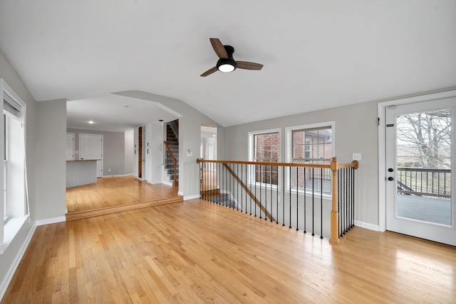 interior space featuring vaulted ceiling, light wood finished floors, and baseboards