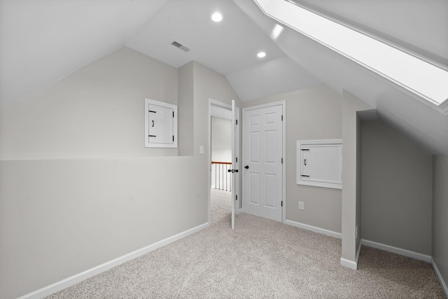 additional living space featuring visible vents, baseboards, lofted ceiling with skylight, carpet, and recessed lighting