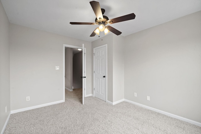 unfurnished bedroom with a closet, baseboards, a ceiling fan, and light colored carpet