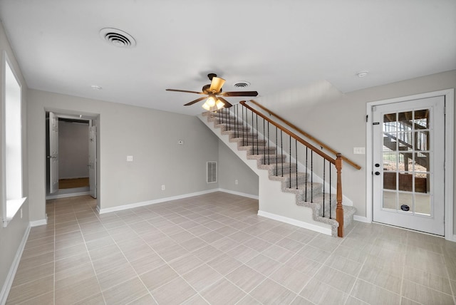 empty room featuring stairway, baseboards, and visible vents