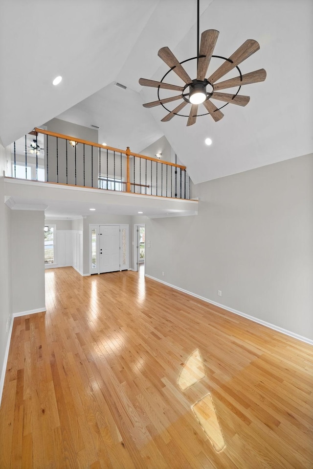 unfurnished living room with recessed lighting, ceiling fan, high vaulted ceiling, light wood-type flooring, and baseboards