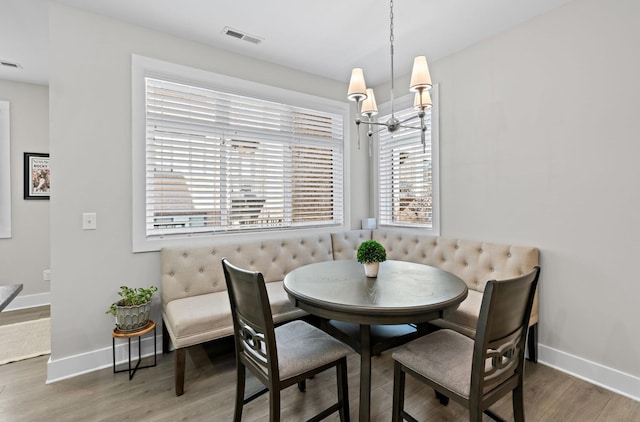 dining room with dark wood-style flooring, visible vents, and baseboards