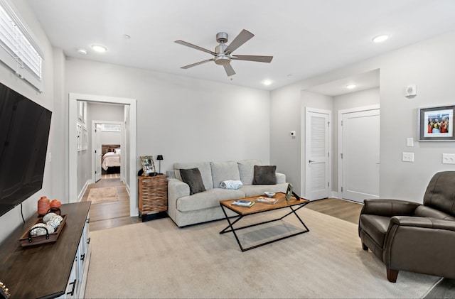 living room featuring light wood finished floors, ceiling fan, and recessed lighting