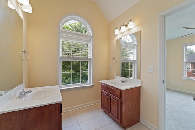 full bath featuring lofted ceiling, tile patterned flooring, two vanities, and a sink