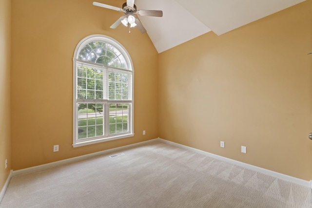 spare room with ceiling fan, light colored carpet, visible vents, baseboards, and vaulted ceiling