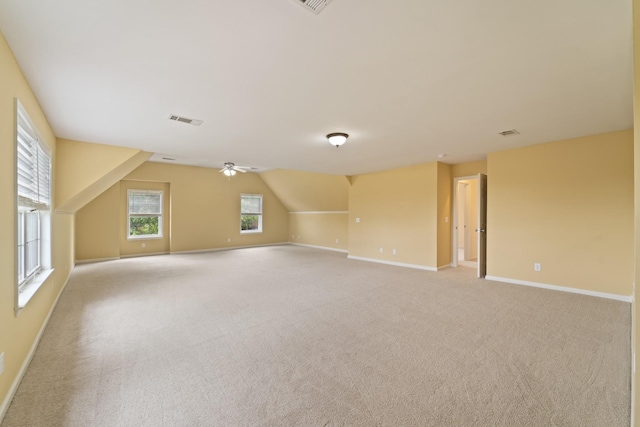 bonus room with visible vents, baseboards, light colored carpet, ceiling fan, and vaulted ceiling