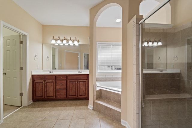 bathroom with tile patterned flooring, a sink, a shower stall, a bath, and double vanity