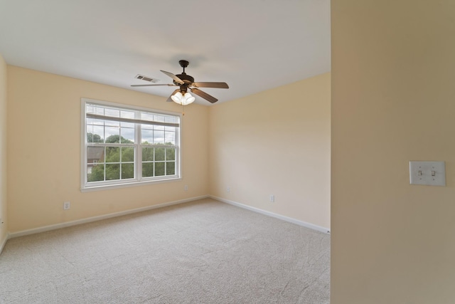 empty room with light carpet, baseboards, visible vents, and ceiling fan