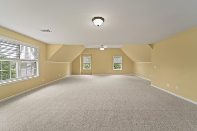 bonus room with visible vents, plenty of natural light, light carpet, and baseboards