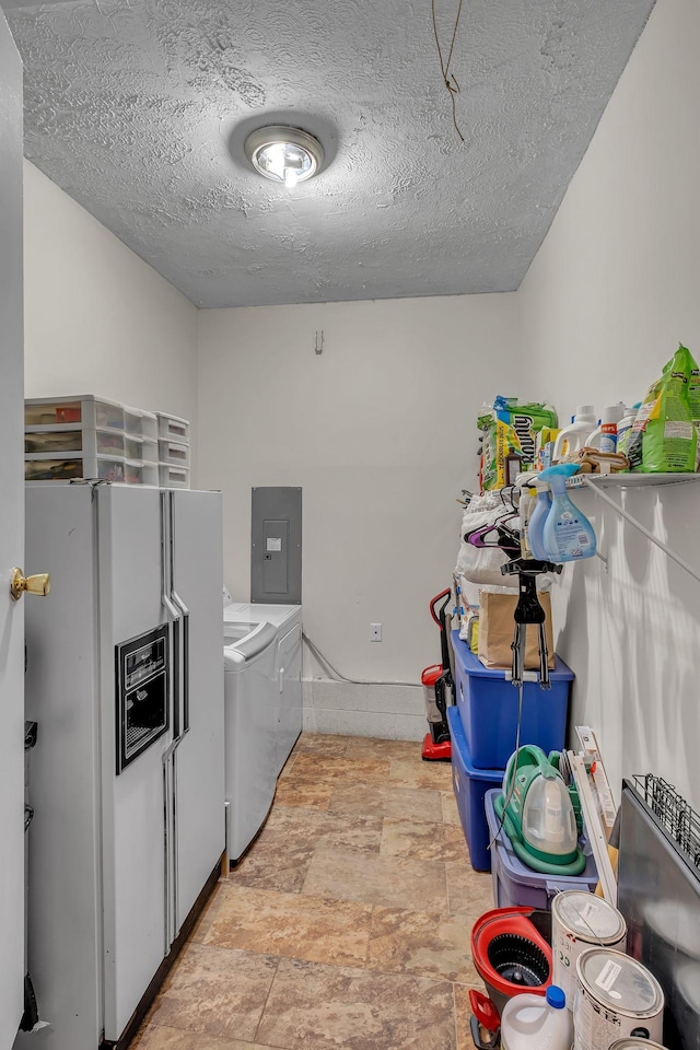 laundry room with washer and dryer, laundry area, electric panel, and a textured ceiling