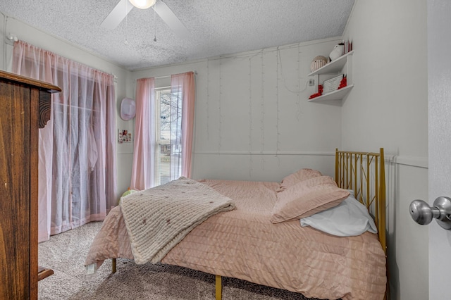 carpeted bedroom with a ceiling fan and a textured ceiling