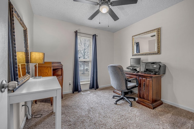 carpeted home office with a textured ceiling, a ceiling fan, and baseboards