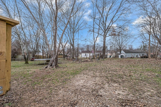 view of yard featuring a trampoline and a residential view