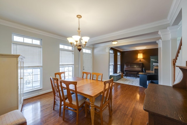 dining room with baseboards, stairway, wood finished floors, an inviting chandelier, and crown molding