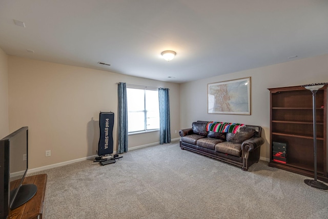 living area with baseboards, visible vents, and light colored carpet