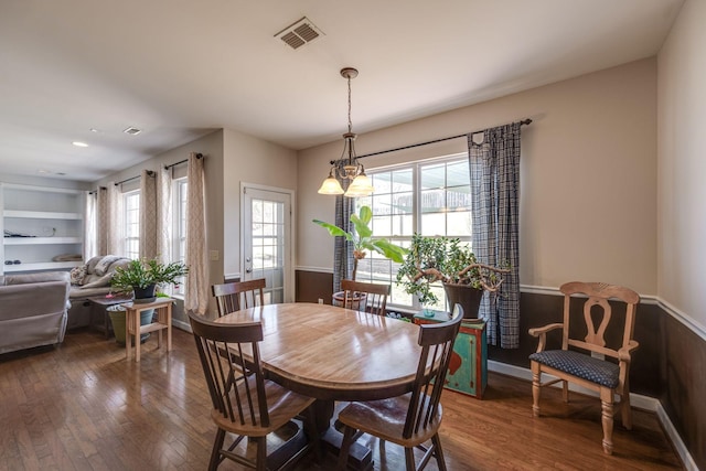 dining space featuring baseboards, a notable chandelier, visible vents, and dark wood-style flooring