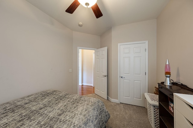 bedroom with light carpet, baseboards, and a ceiling fan