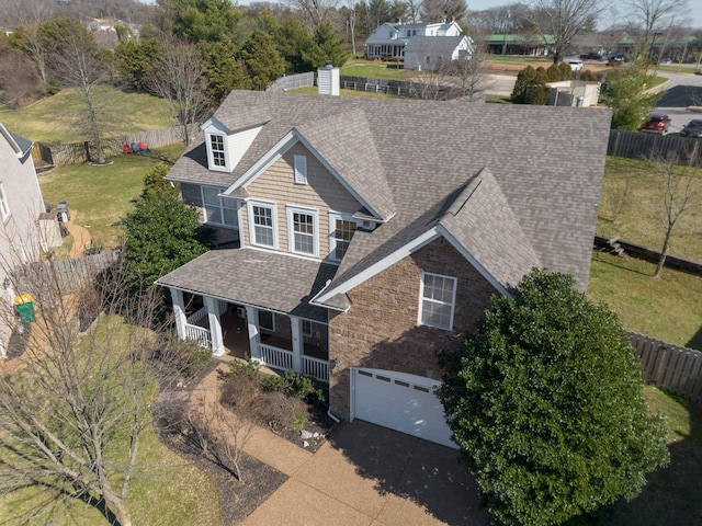 view of front of property featuring a porch, roof with shingles, driveway, and an attached garage