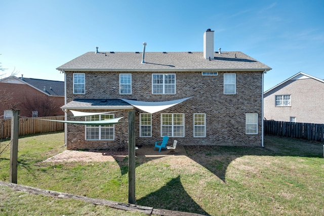 rear view of house with a patio area, a fenced backyard, and a yard