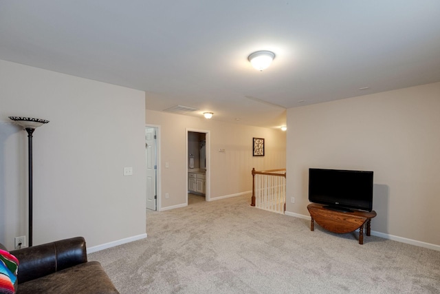 living area featuring baseboards, light carpet, and an upstairs landing