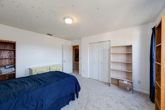 bedroom featuring light carpet, a closet, visible vents, and baseboards