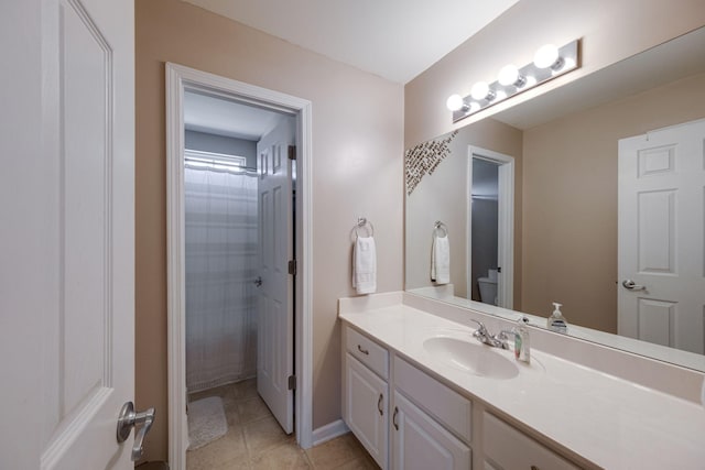 bathroom with tile patterned flooring, curtained shower, vanity, and toilet