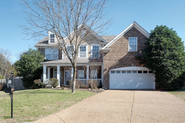 traditional-style house featuring covered porch, concrete driveway, brick siding, and a front yard