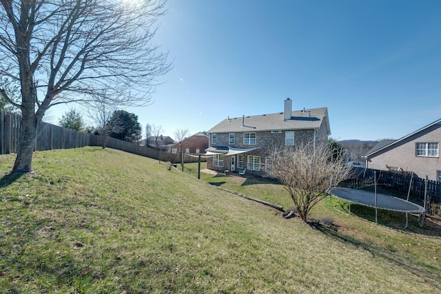 view of yard featuring a fenced backyard and a trampoline